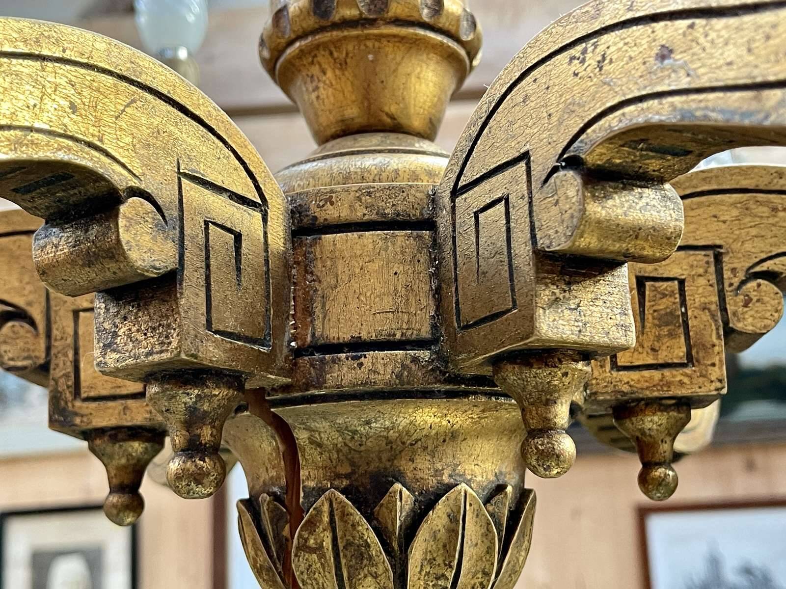 Golden wooden chandelier with crystal pendants from the 19th century.