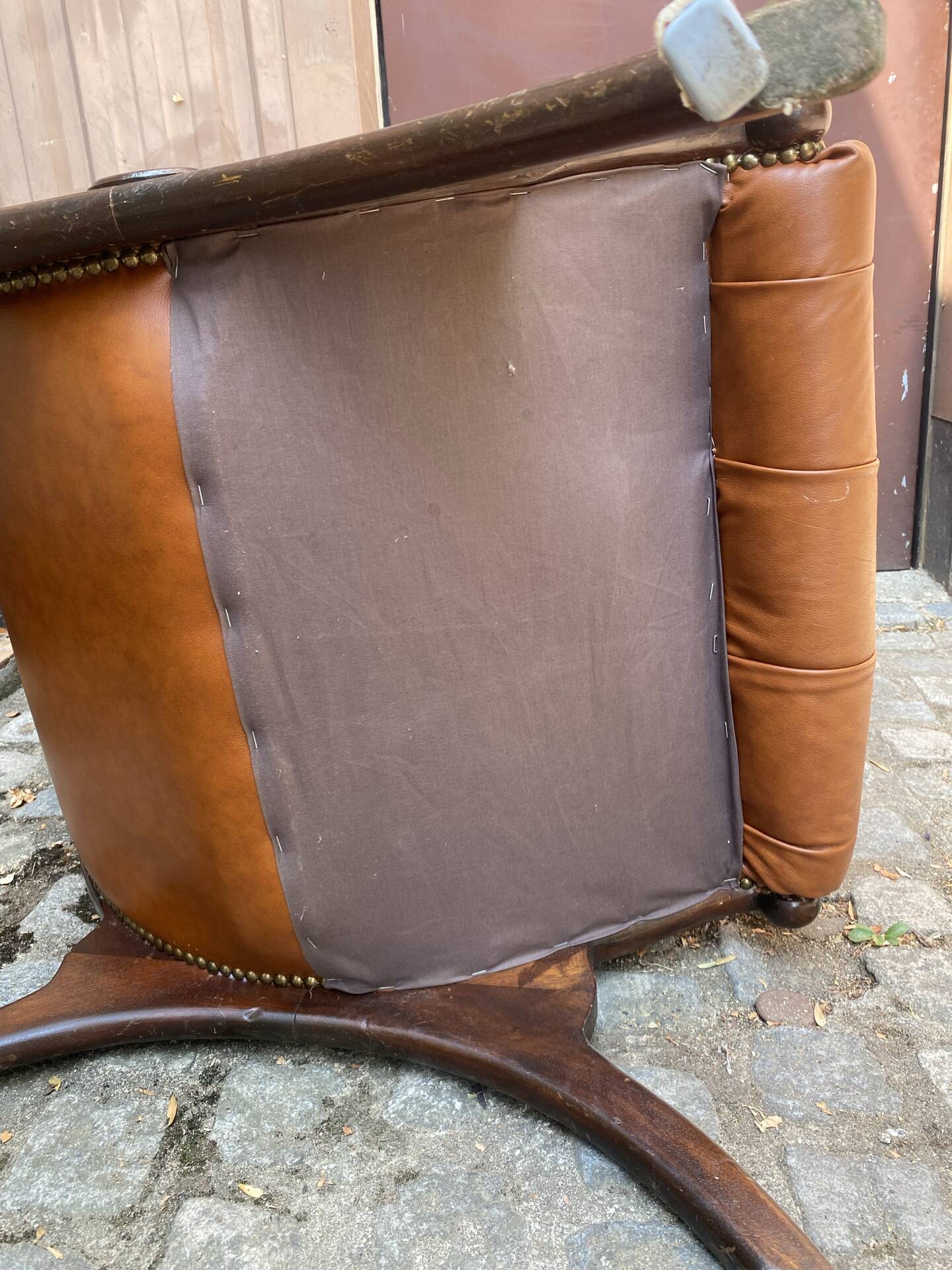 Chesterfield armchair in leather and carved solid wood