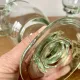 4 stemmed glasses made of handcrafted blown glass in green hue.