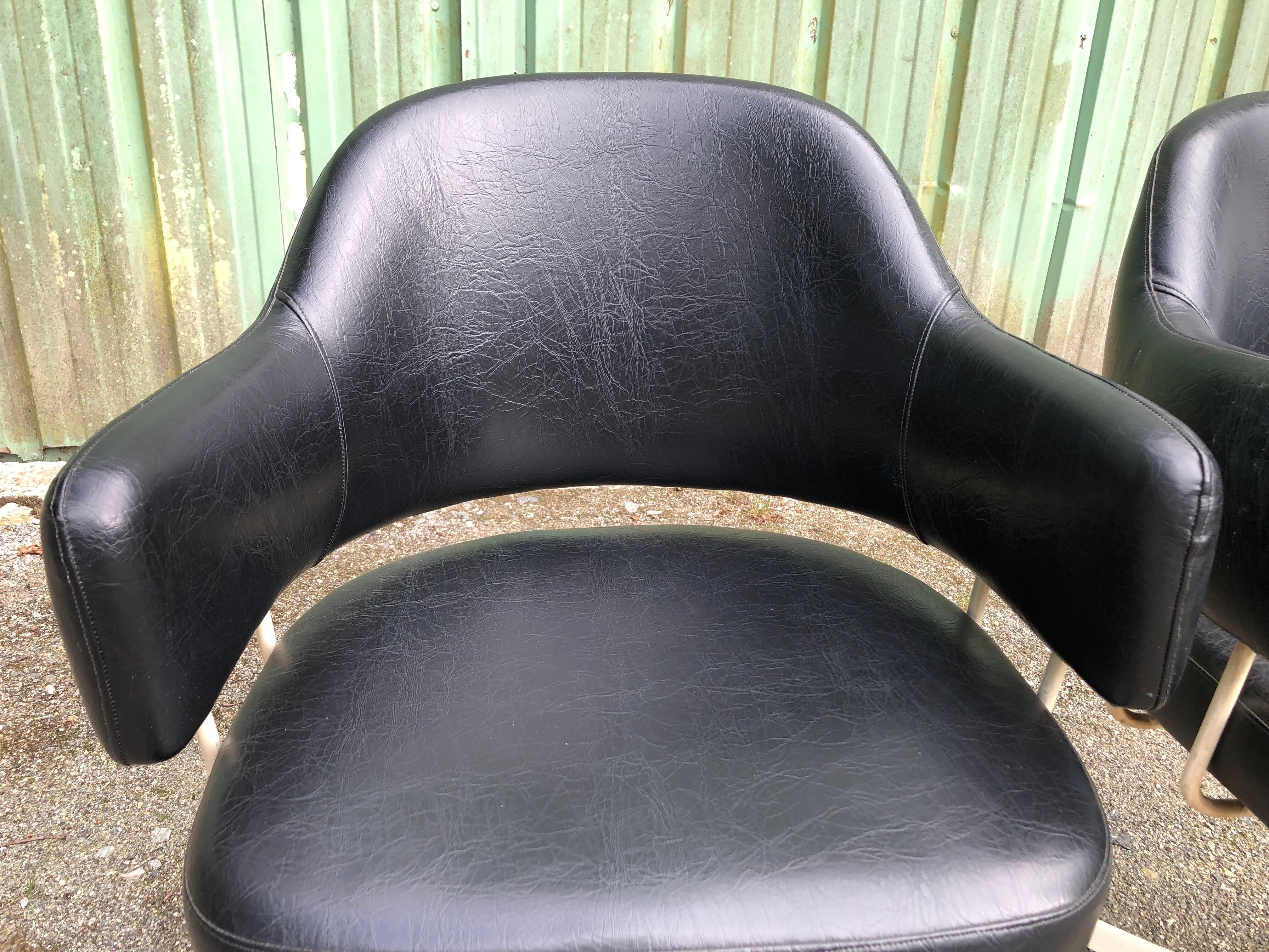 Pair of vintage armchairs in black skai with metal legs.