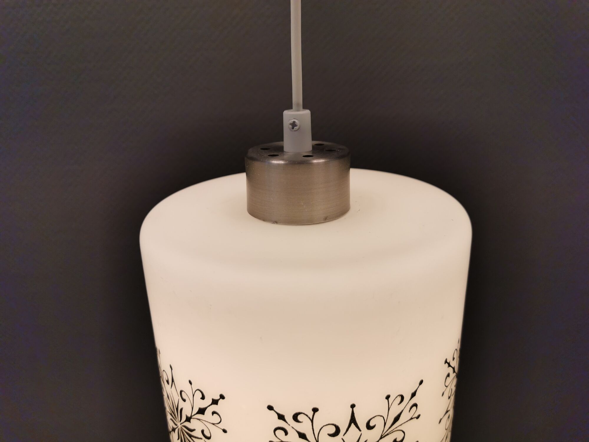 Scandinavian hanging lamp in white glass with inlayed black motifs.
