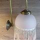 Brass swan neck wall lamp with pink glass globe and Charleston tassels