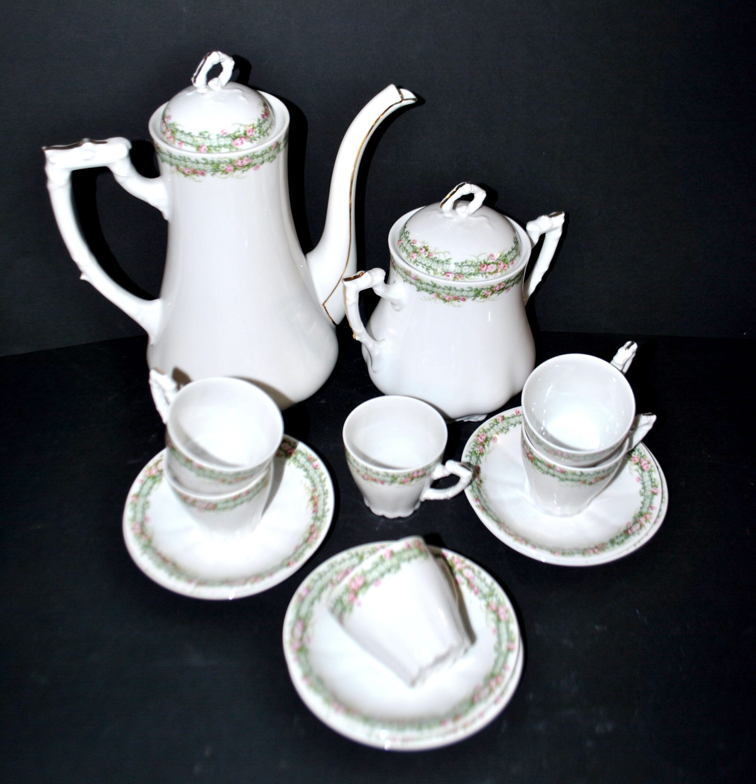 Vintage Limoges coffee service with pink and green floral decoration, coffee pot, sugar bowl, and 6 cups.
