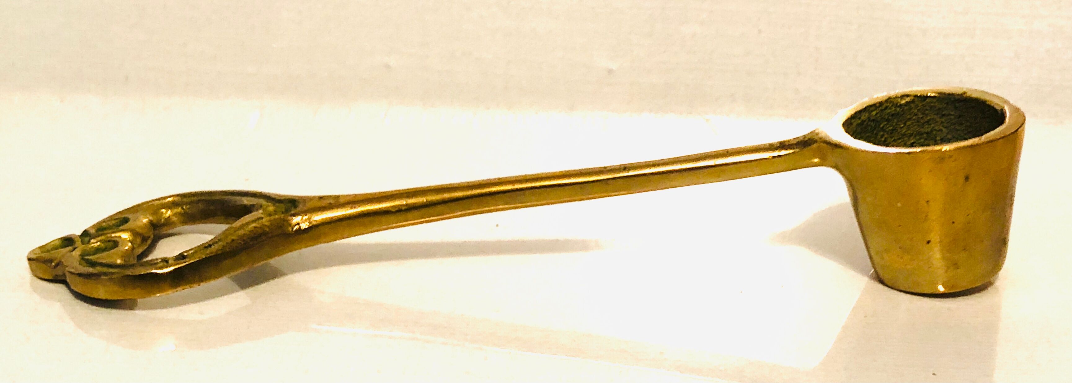 Antique candle extinguisher in golden brass