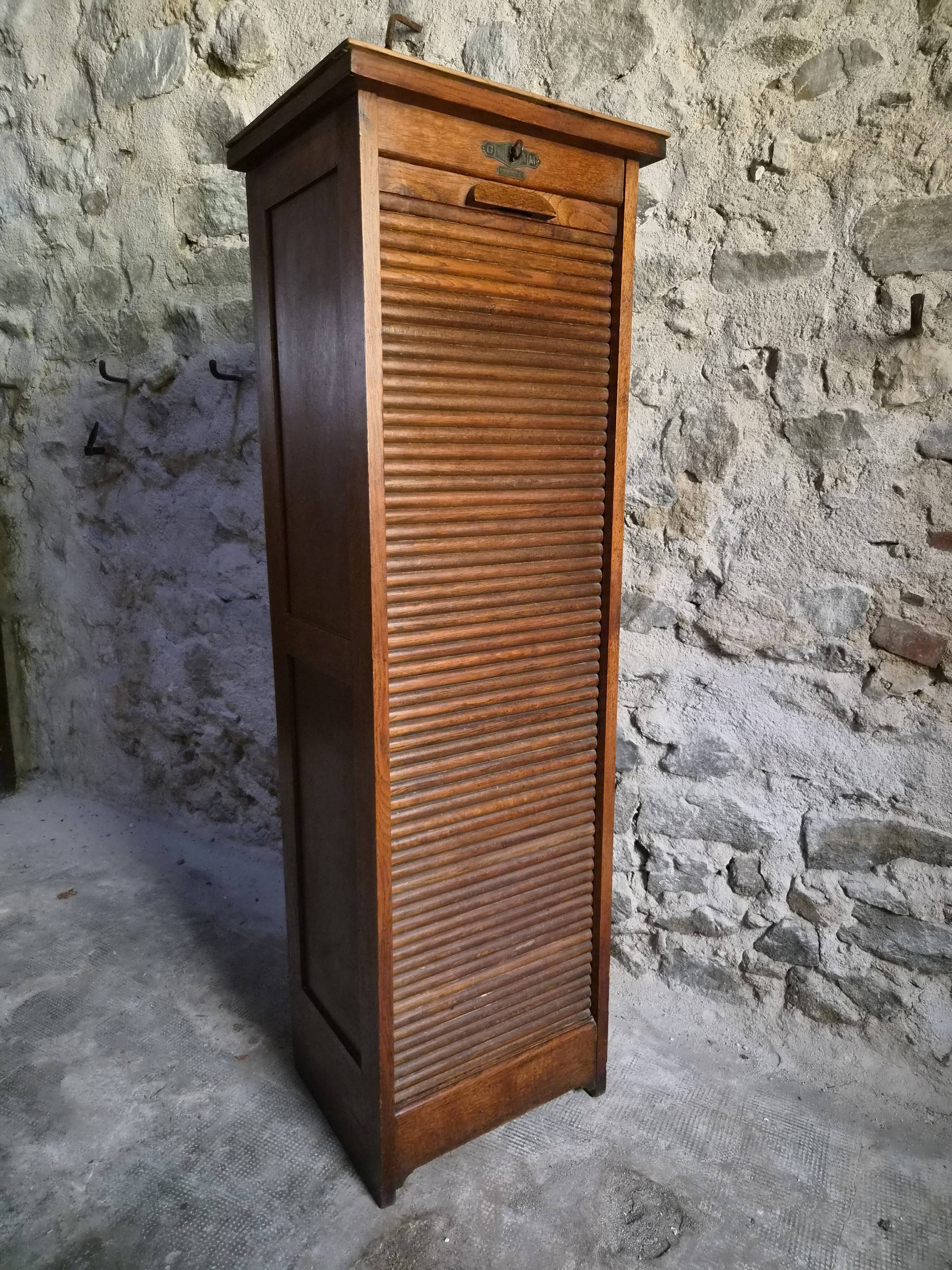 French antique wardrobe with curtain in oak, circa 1920–1930.