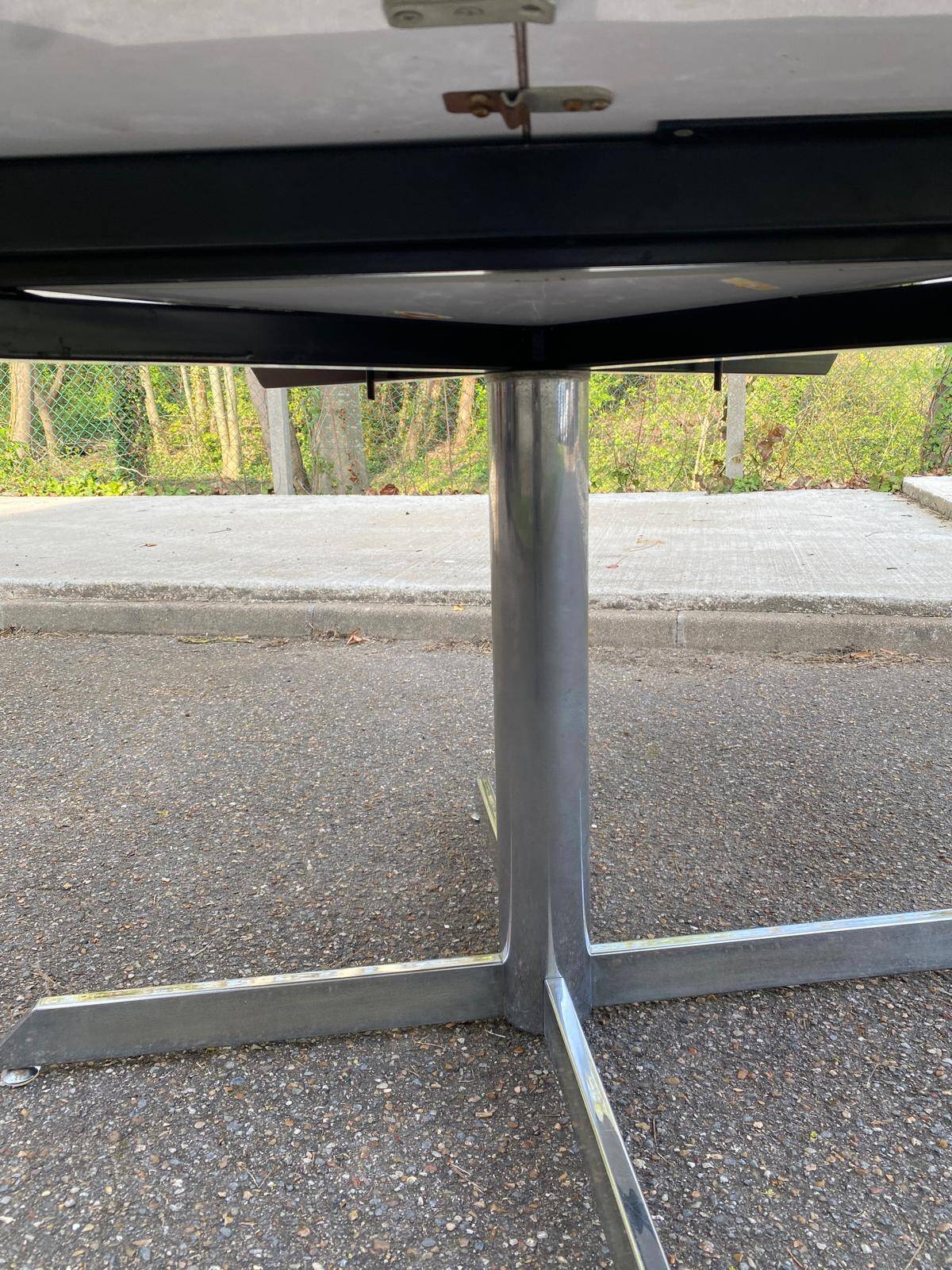 White dining table with a central pedestal, extendable, from the 1970s.
