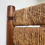 Brutalist style bed with chain and straw