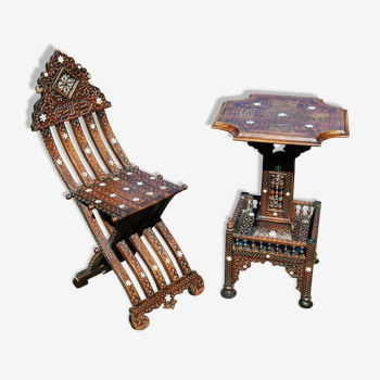 A folding chair and a carved Syrian table with 19th-century mother-of-pearl inlays.