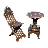 A folding chair and a carved Syrian table with 19th-century mother-of-pearl inlays.
