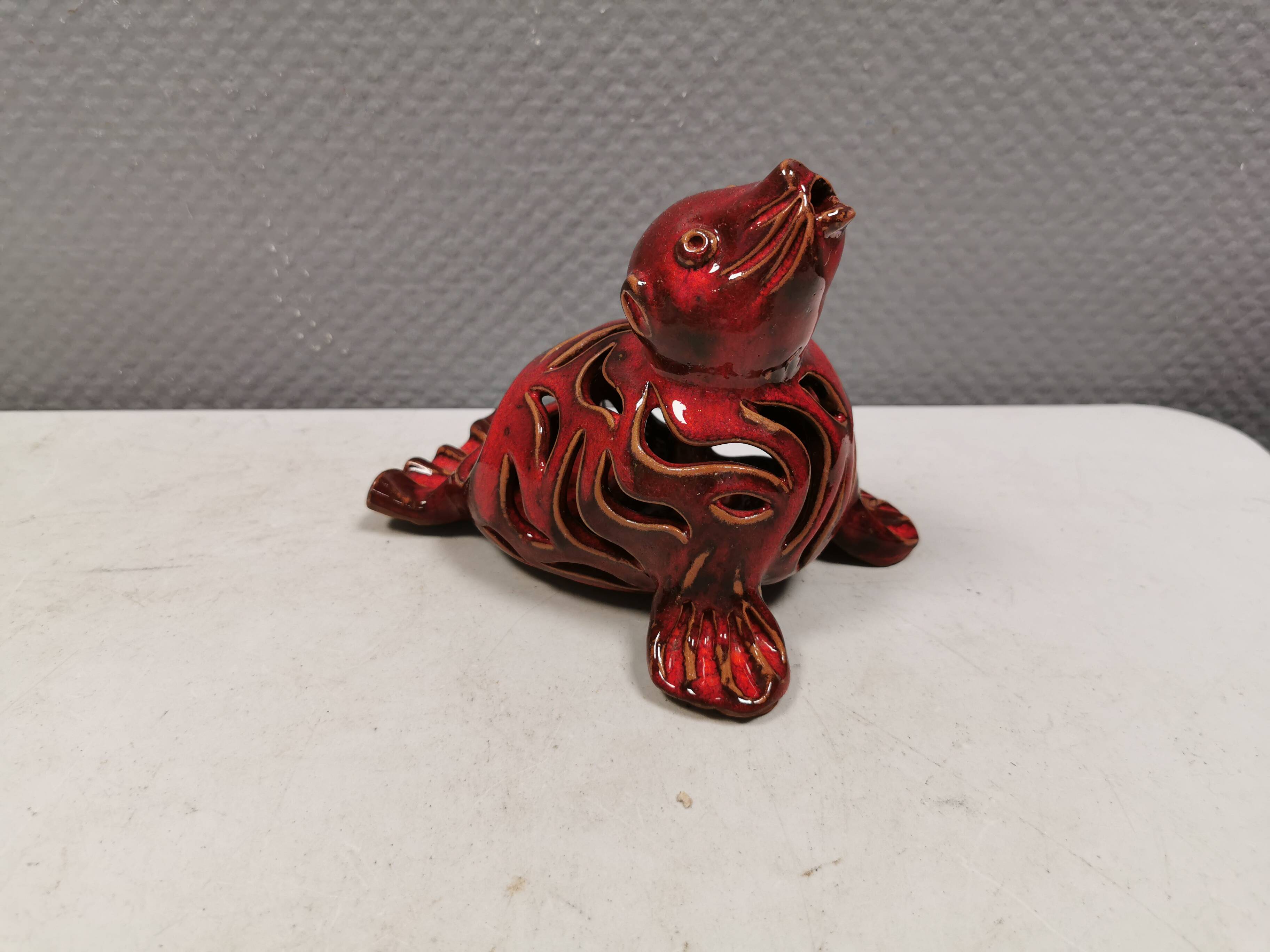 Beautiful seal in ceramic with metallic red glaze.