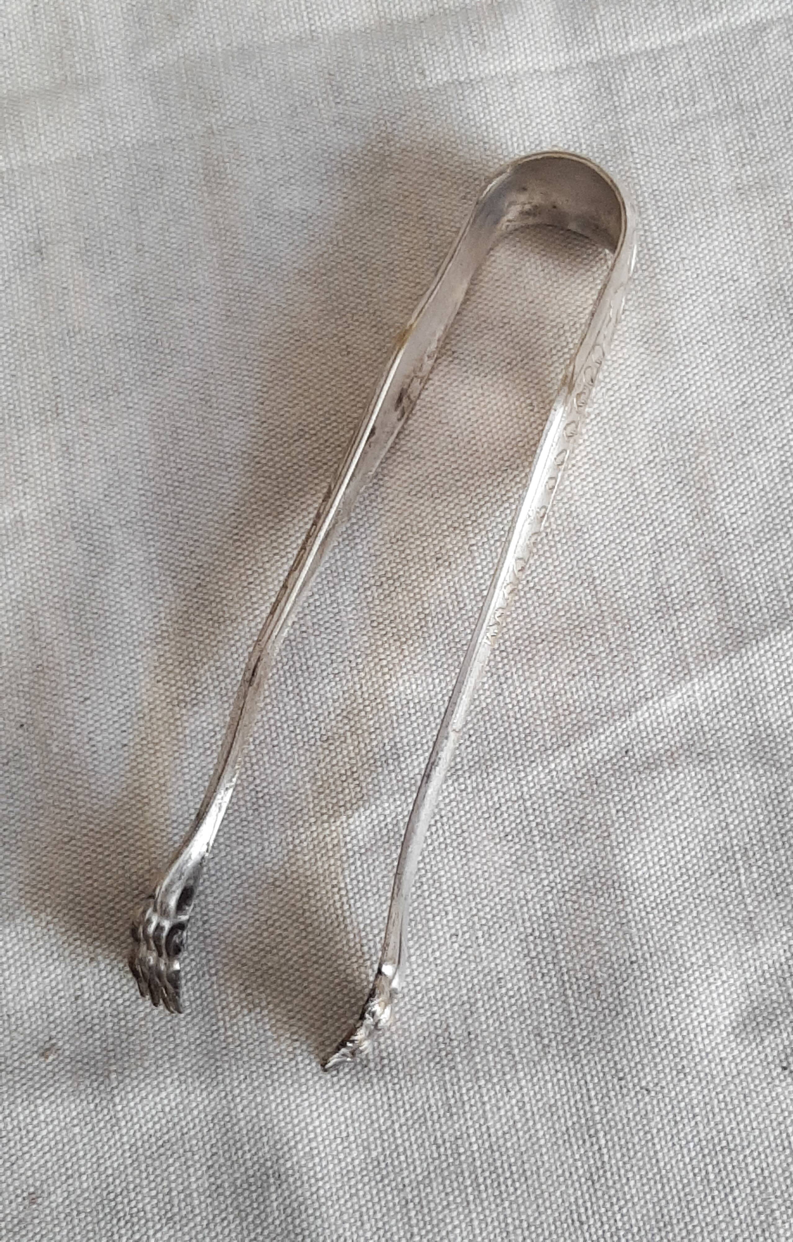 Antique silver-plated sugar tongs with lion's paws.