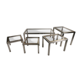 Suite de 5 tables basses en métal chromé, laiton, verre fumé vers 1970