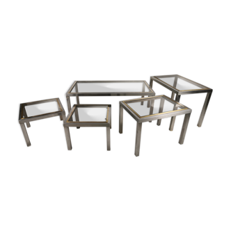 Suite de 5 tables basses en métal chromé, laiton, verre fumé vers 1970