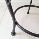 Black iron stool/pouf with its boucle fabric cushion.