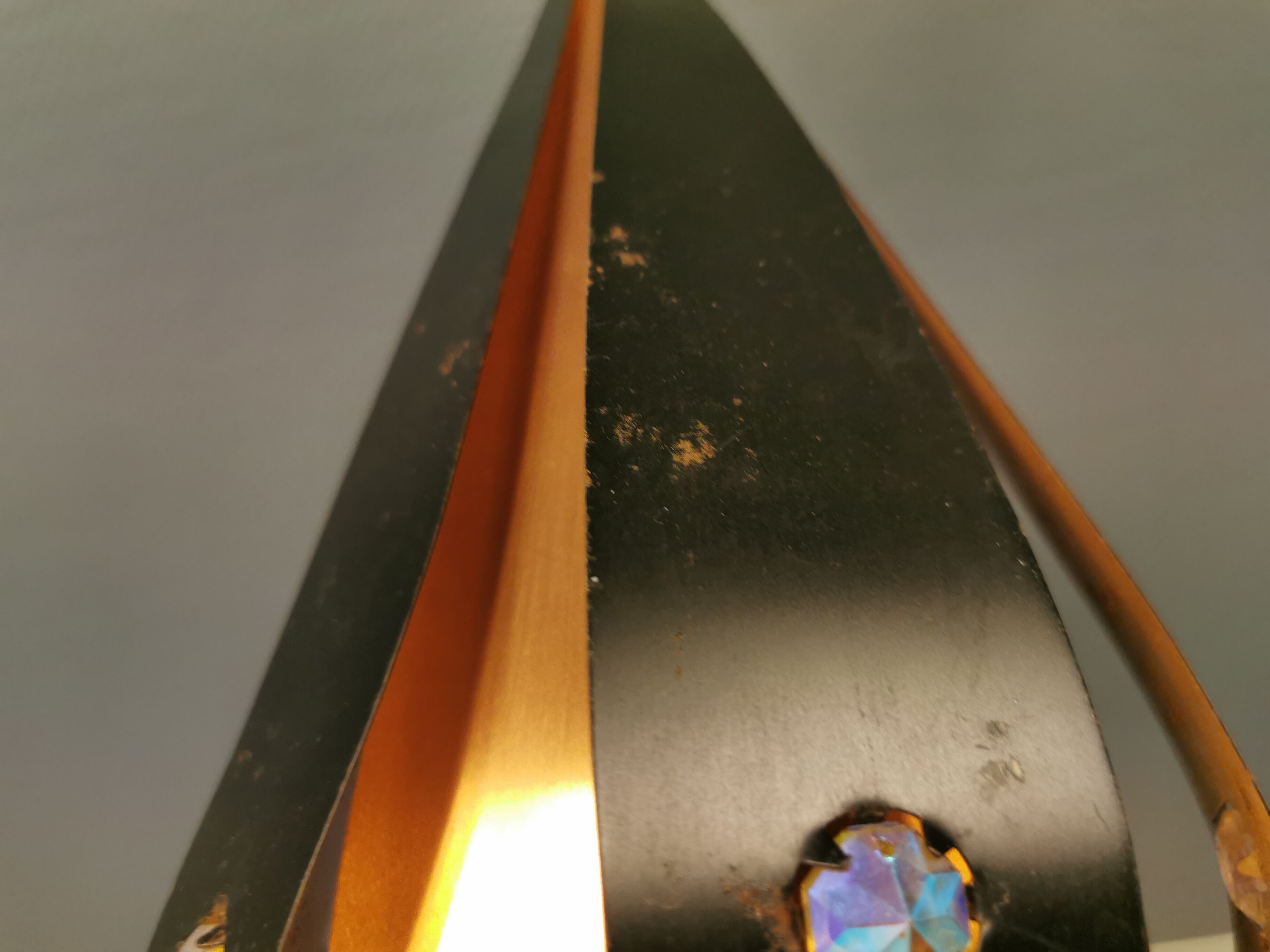 Hanging lamp in thin metal pieces, copper colored and black with prisms.