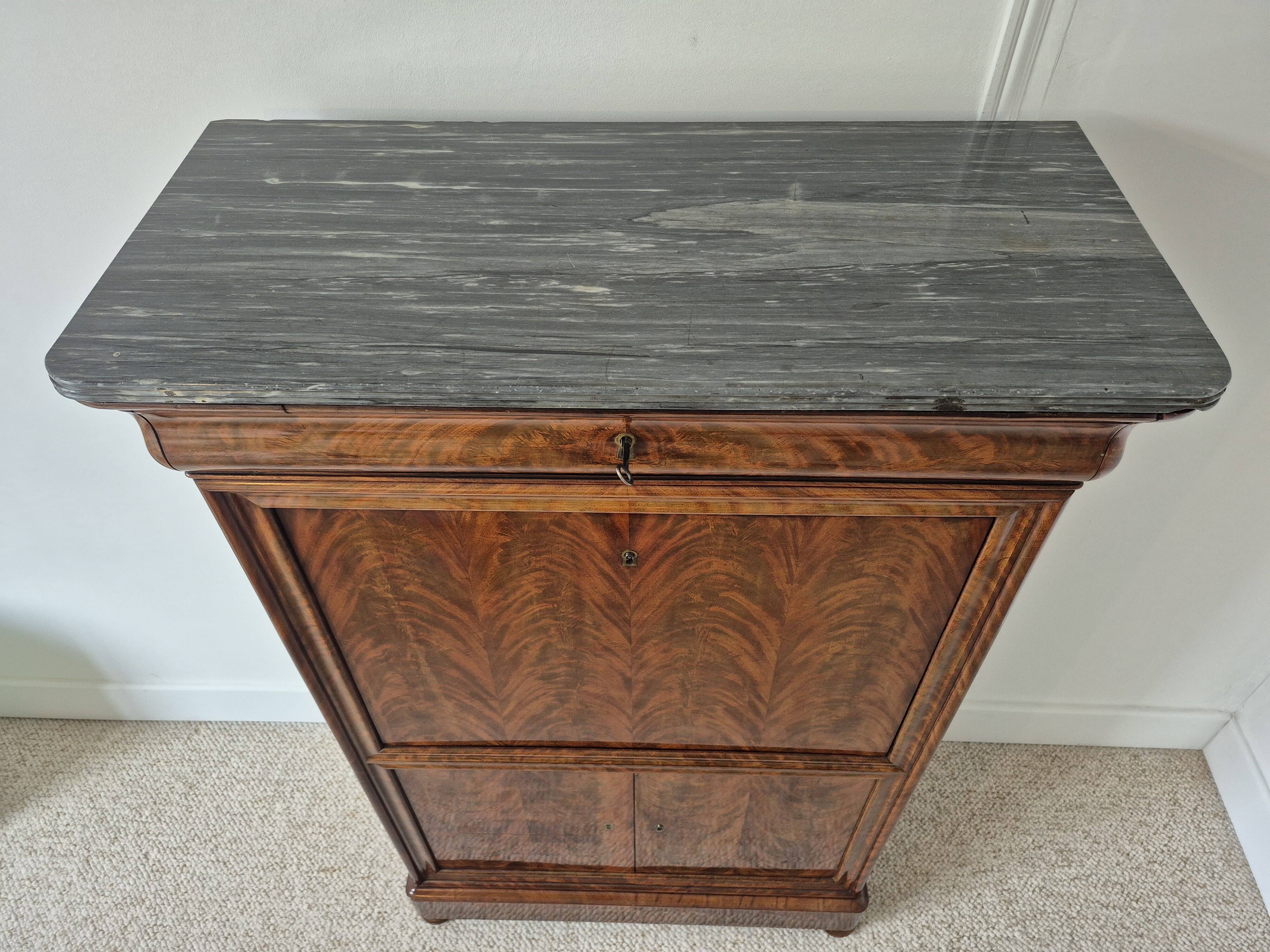 Mahogany secretary desk with marble top and interior mirror.