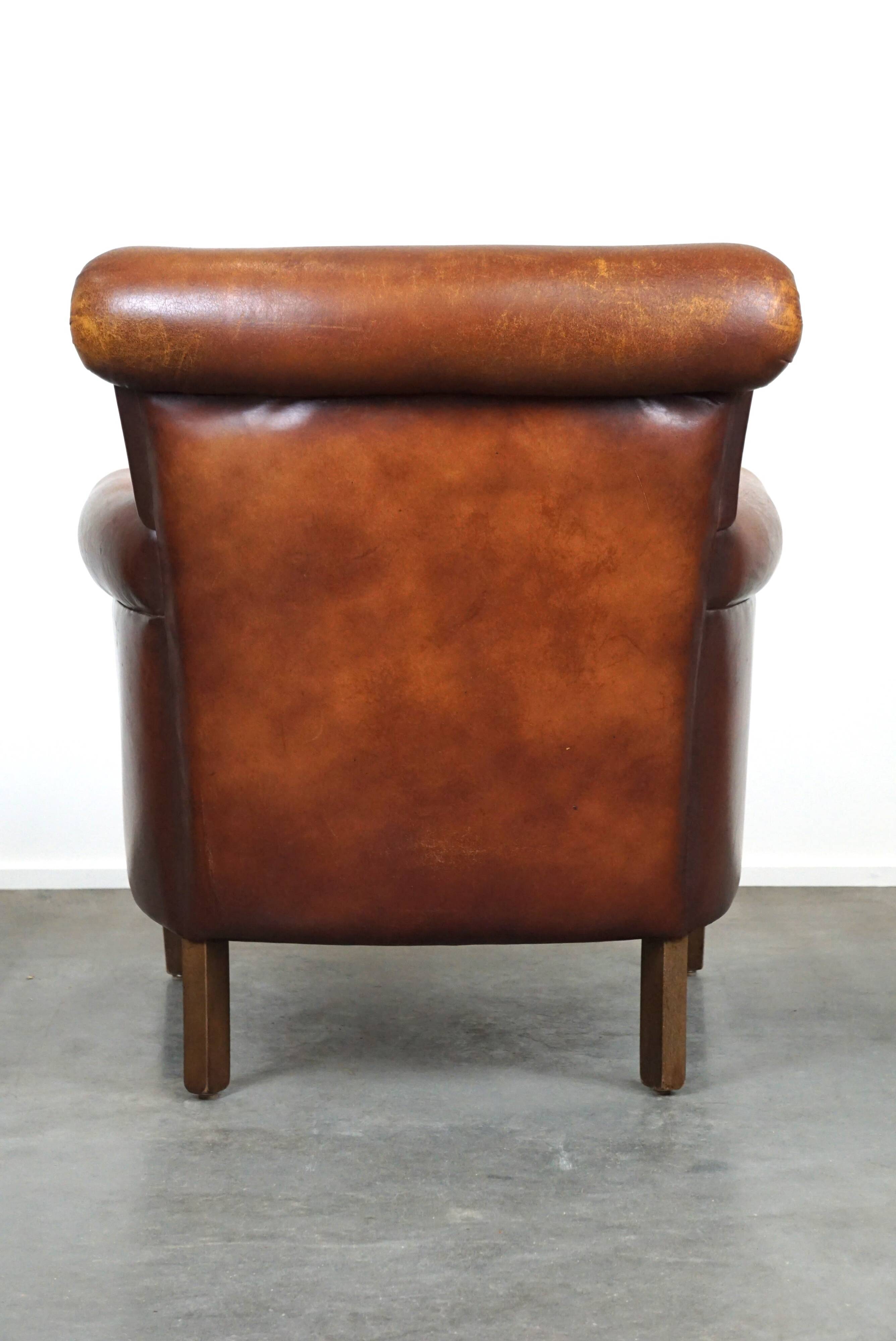 Fauteuil en cuir de mouton robuste et usé mais très confortable avec une belle patine