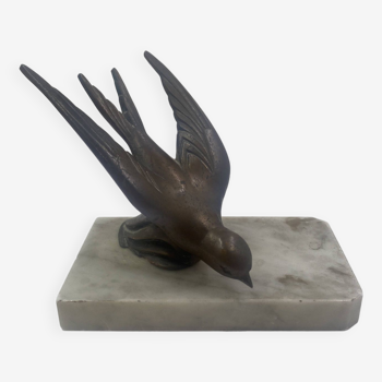 Bronze bird sculpture placed on a marble slab