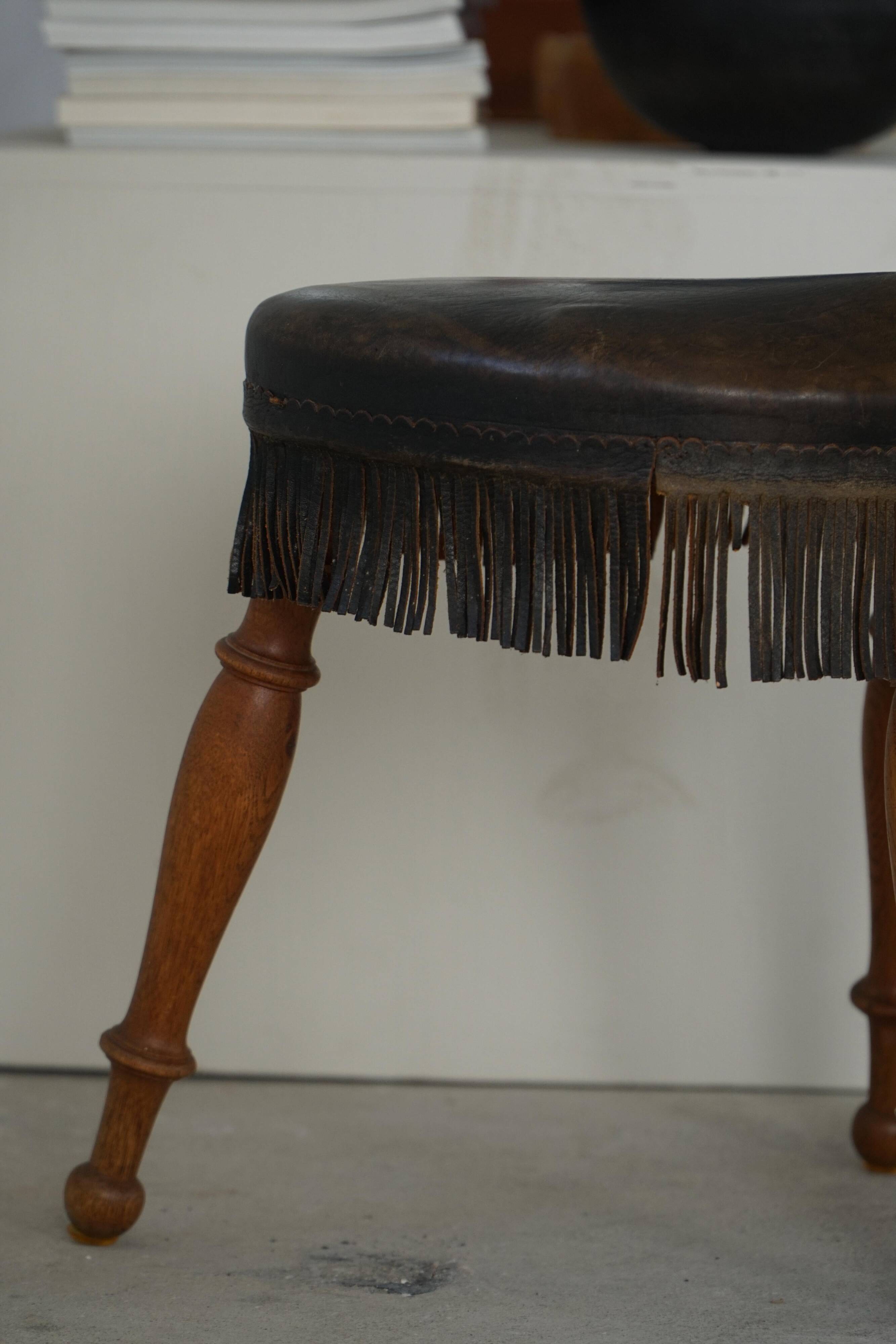 Danish oak tripod stool from the early 20th century with leather fringe, 1930s.