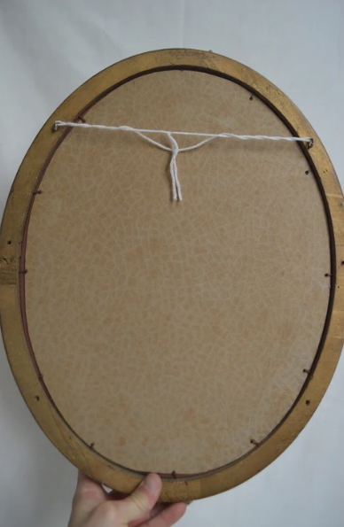 Oval mirror in gilded wood