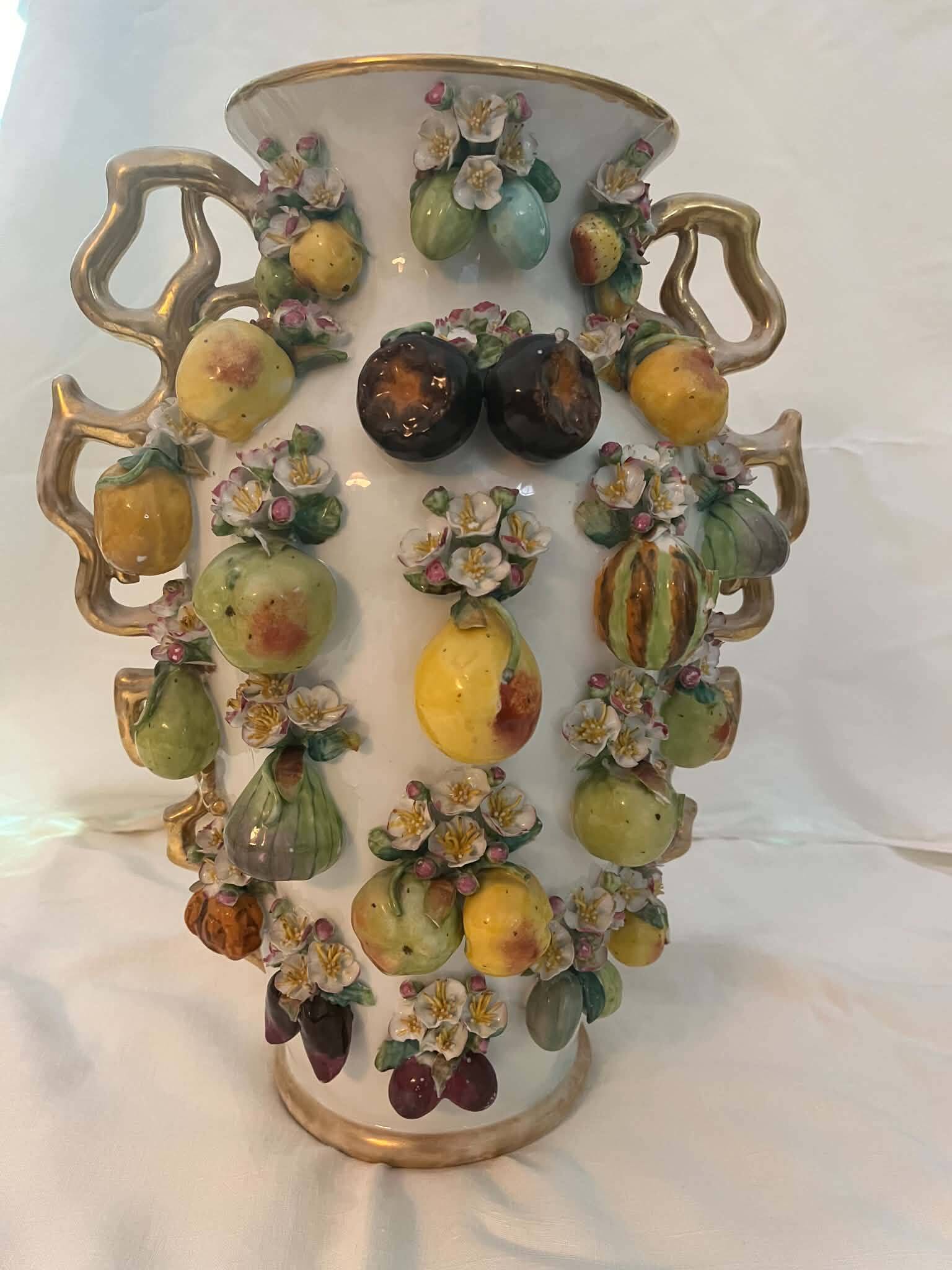 Large antique vase with relief decorations of coloured fruits.