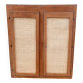 Low cabinet in raw wood and woven raffia.