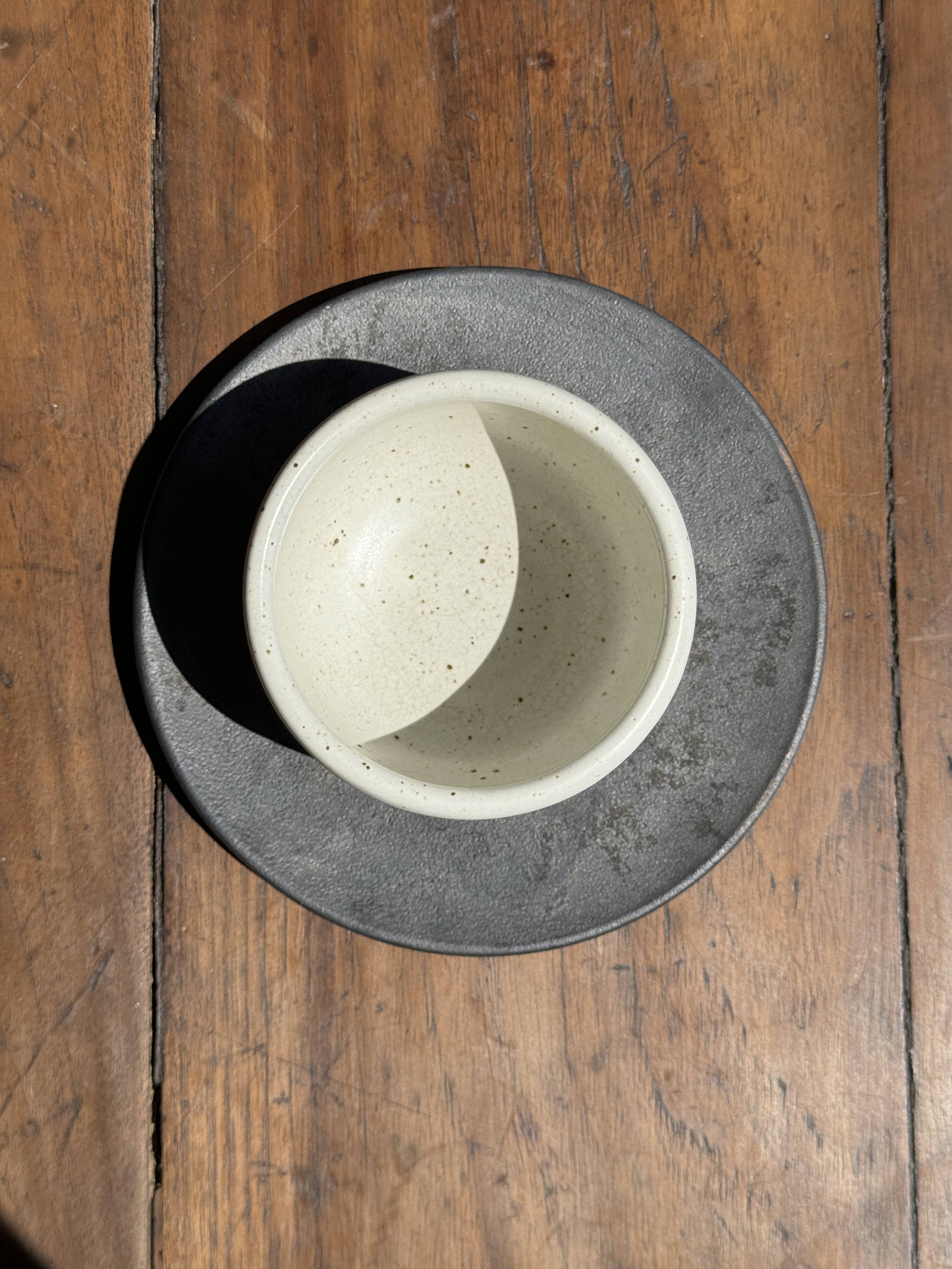 White Indonesian ceramic cup and gray saucer