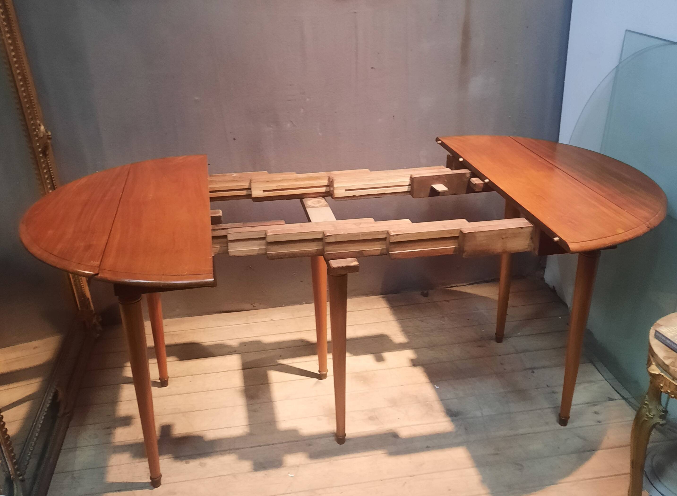 Drop-leaf table with 6 legs and 3 extensions.