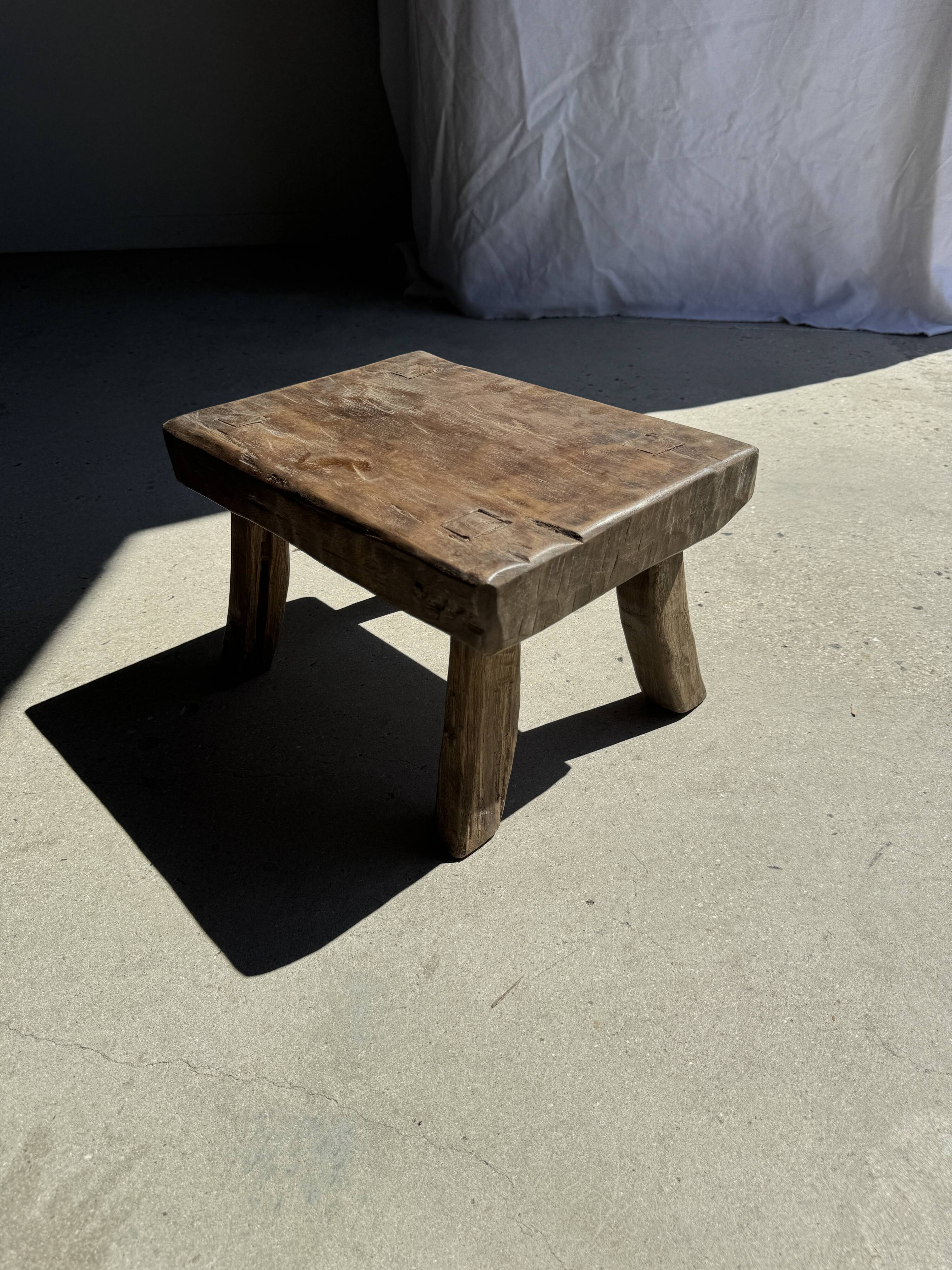Small stool, rectangular solid teak side table with curved legs.