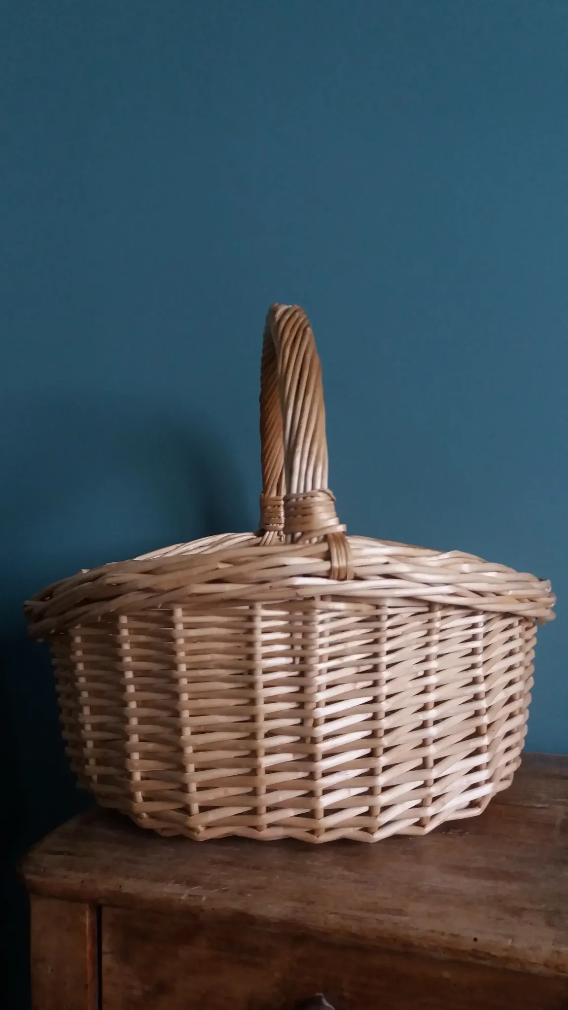 Handcrafted wicker basket with a handle.