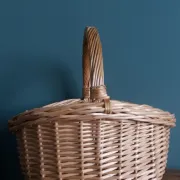 Handcrafted wicker basket with a handle.
