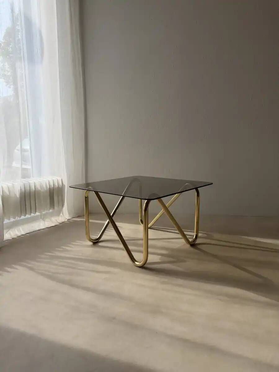 Coffee table with smoked glass and curved metal base