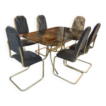 7-piece dining set in gold-plated brass, with a smoked glass top and grey fabric.