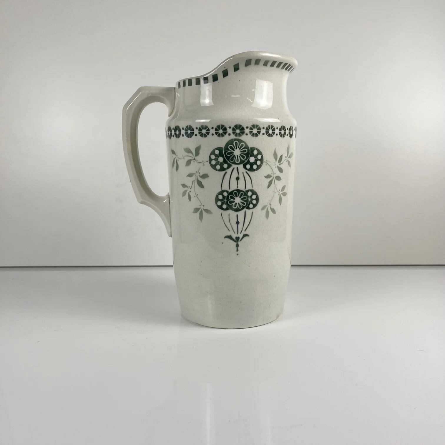 Antique earthenware pitcher, green floral decoration, fine ironstone from the late 19th to early 20th century.