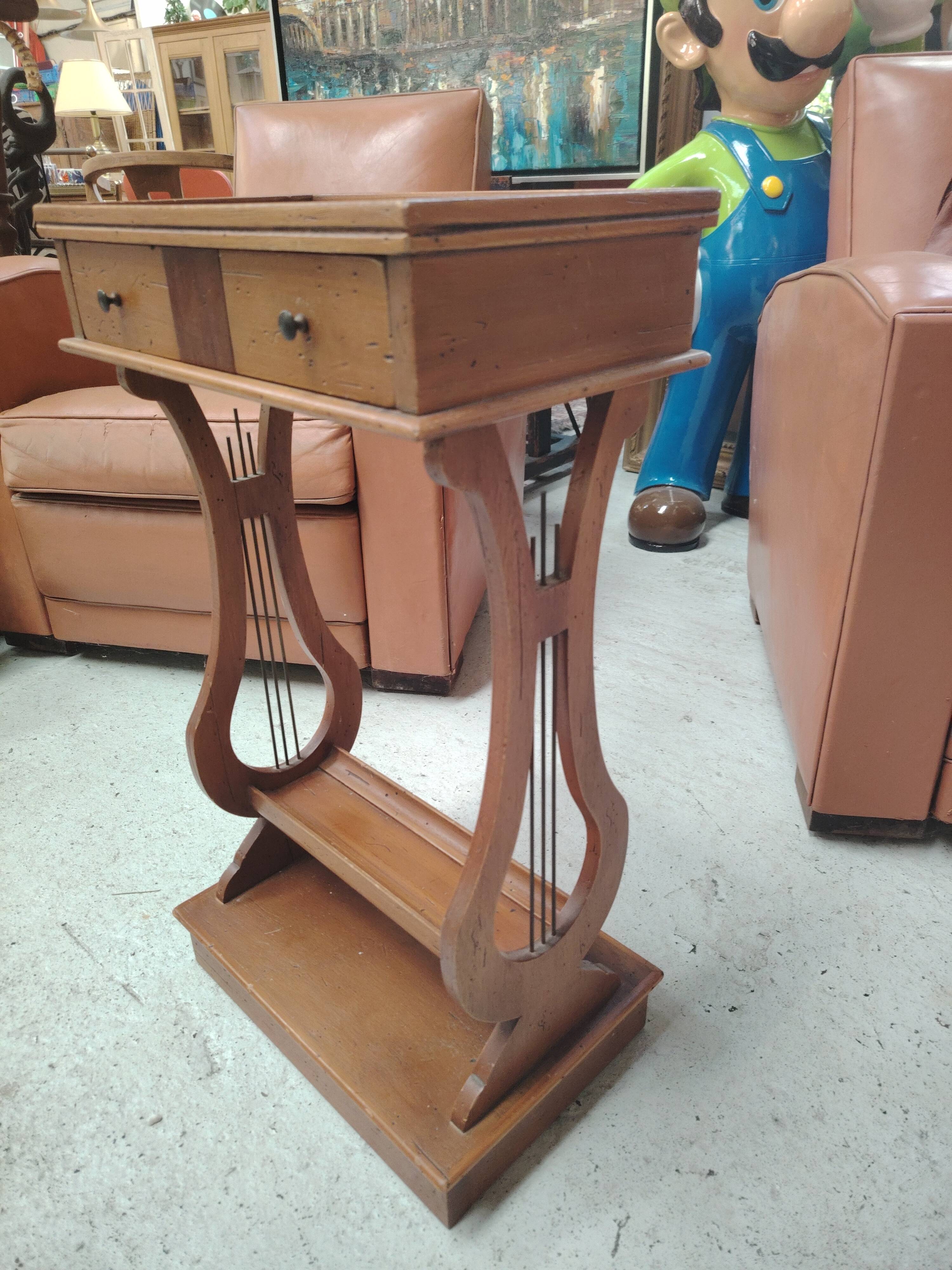Vintage end table with lyre legs and two drawers.