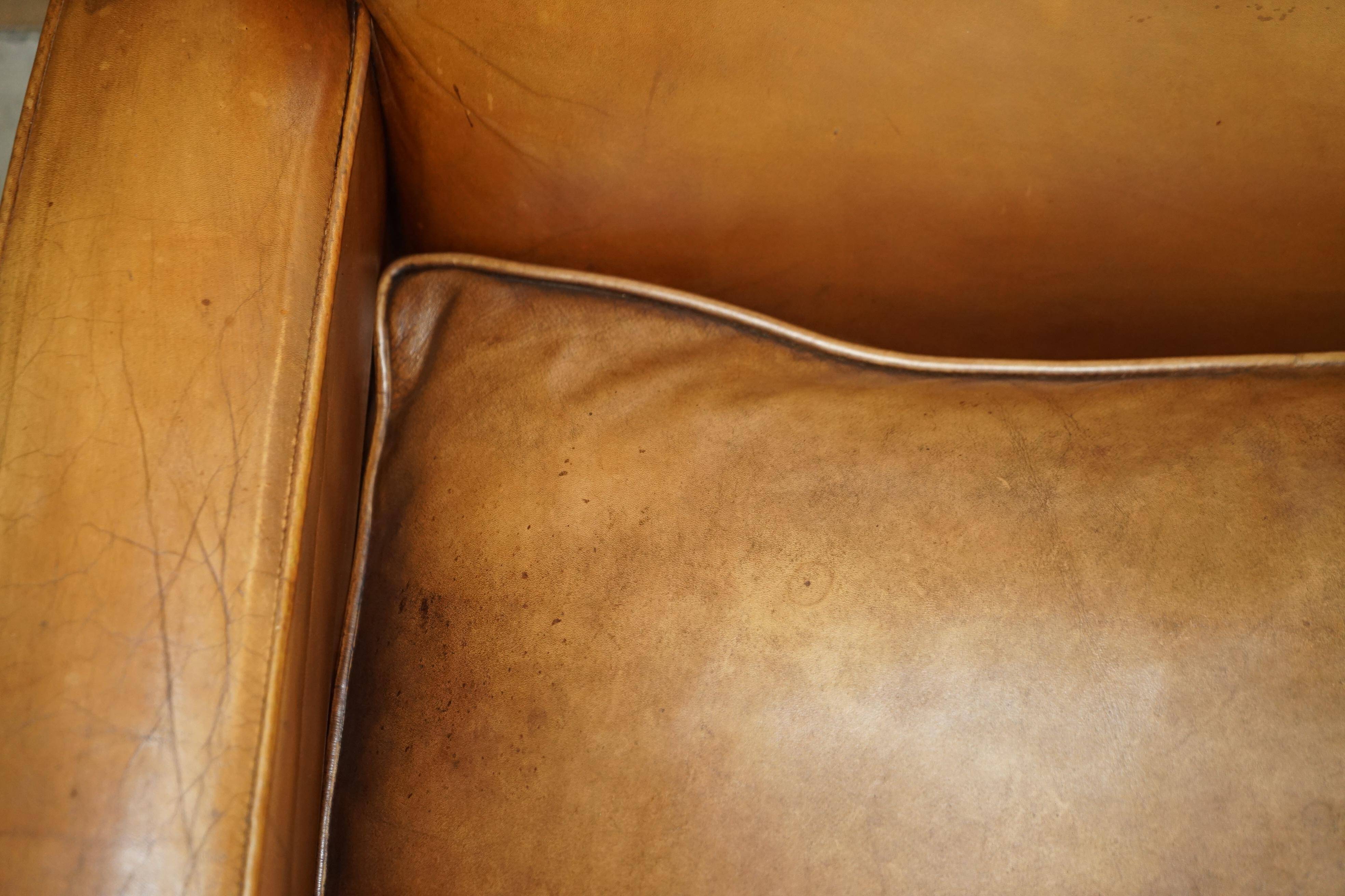 Three-seater Art Deco style leather sofa with feather cushions.