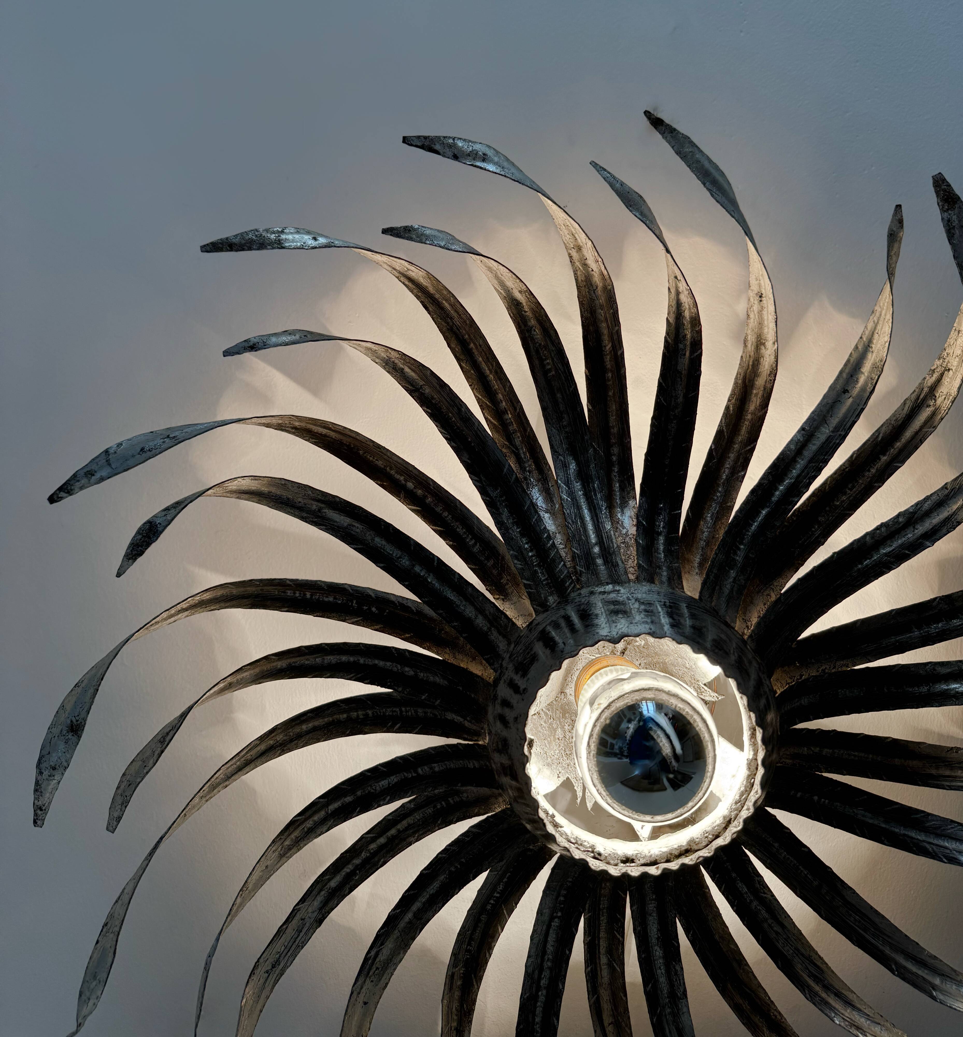 Silver wrought iron sunburst wall light from the 1960s.