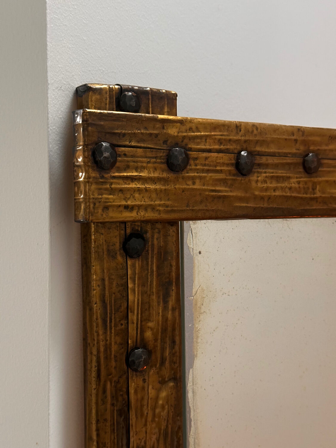 Brutalist mirror with a hammered copper and brass frame.