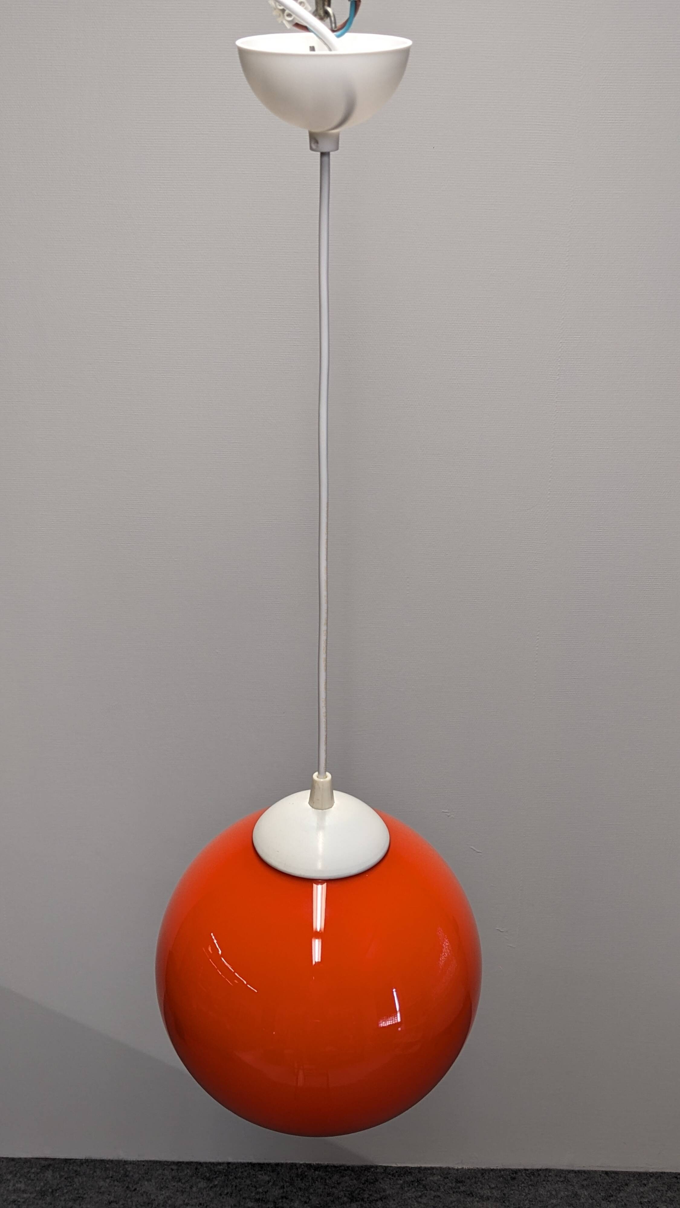Pair of spherical pendant lights in orange opaline, France circa 1970.