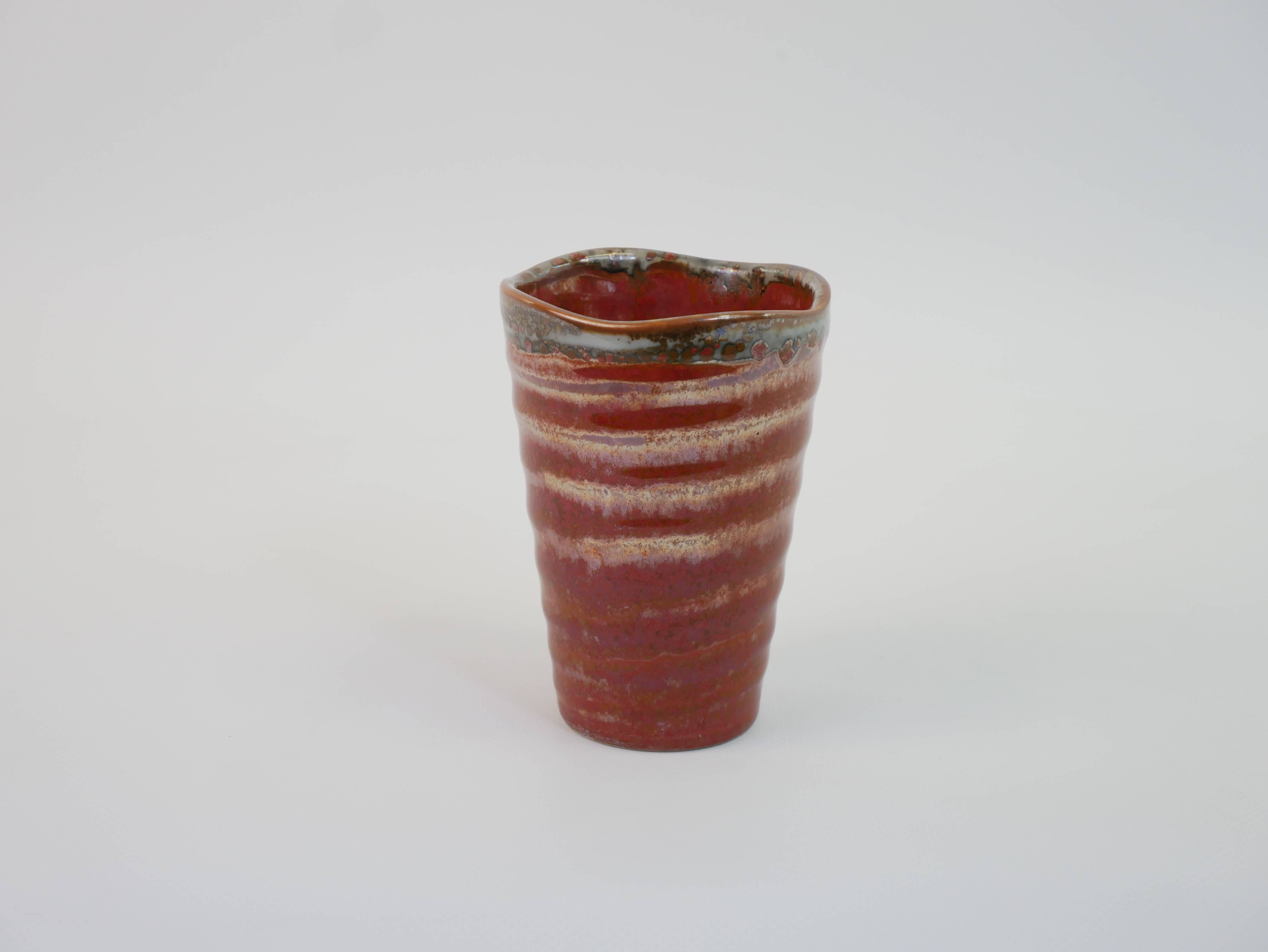 Small orange glazed ceramic cup