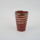 Small orange glazed ceramic cup
