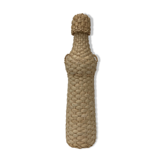 Bottle surrounded by wicker or raffia