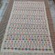 White carpet with Berber motifs pink green and blue
