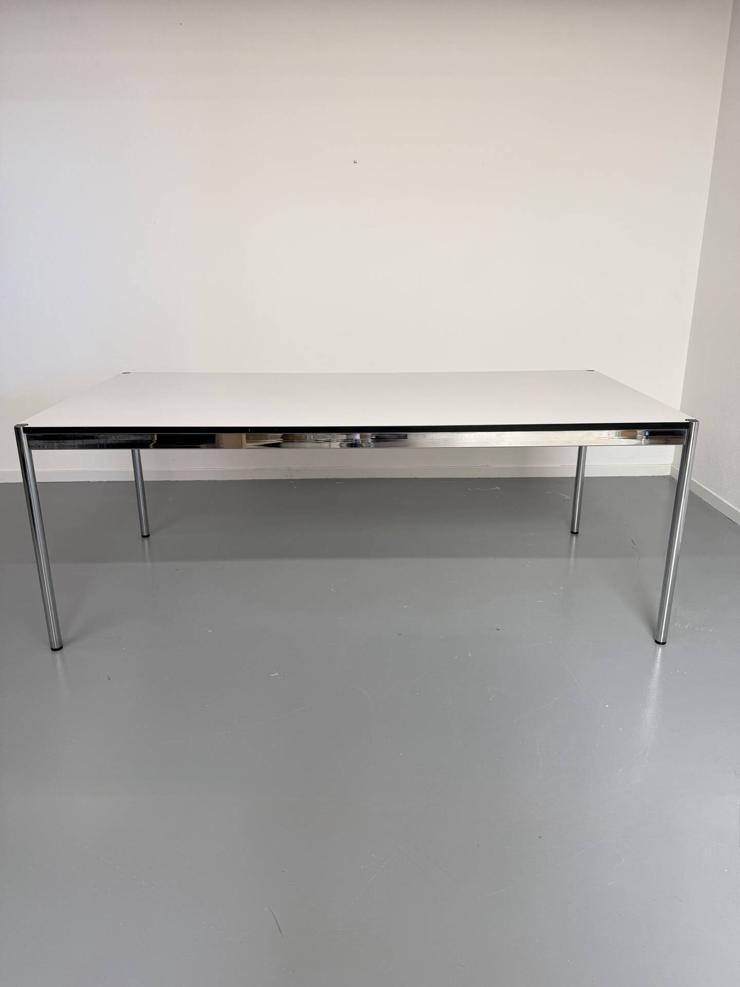 Large table design USM Haller with a white top and chrome structure.