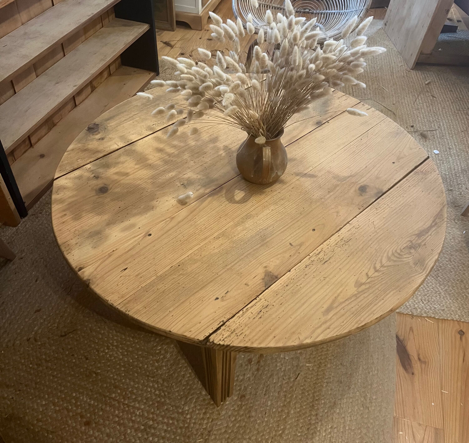 Large round antique coffee table made of raw solid wood.