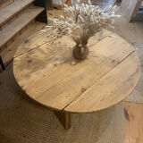 Large round antique coffee table made of raw solid wood.
