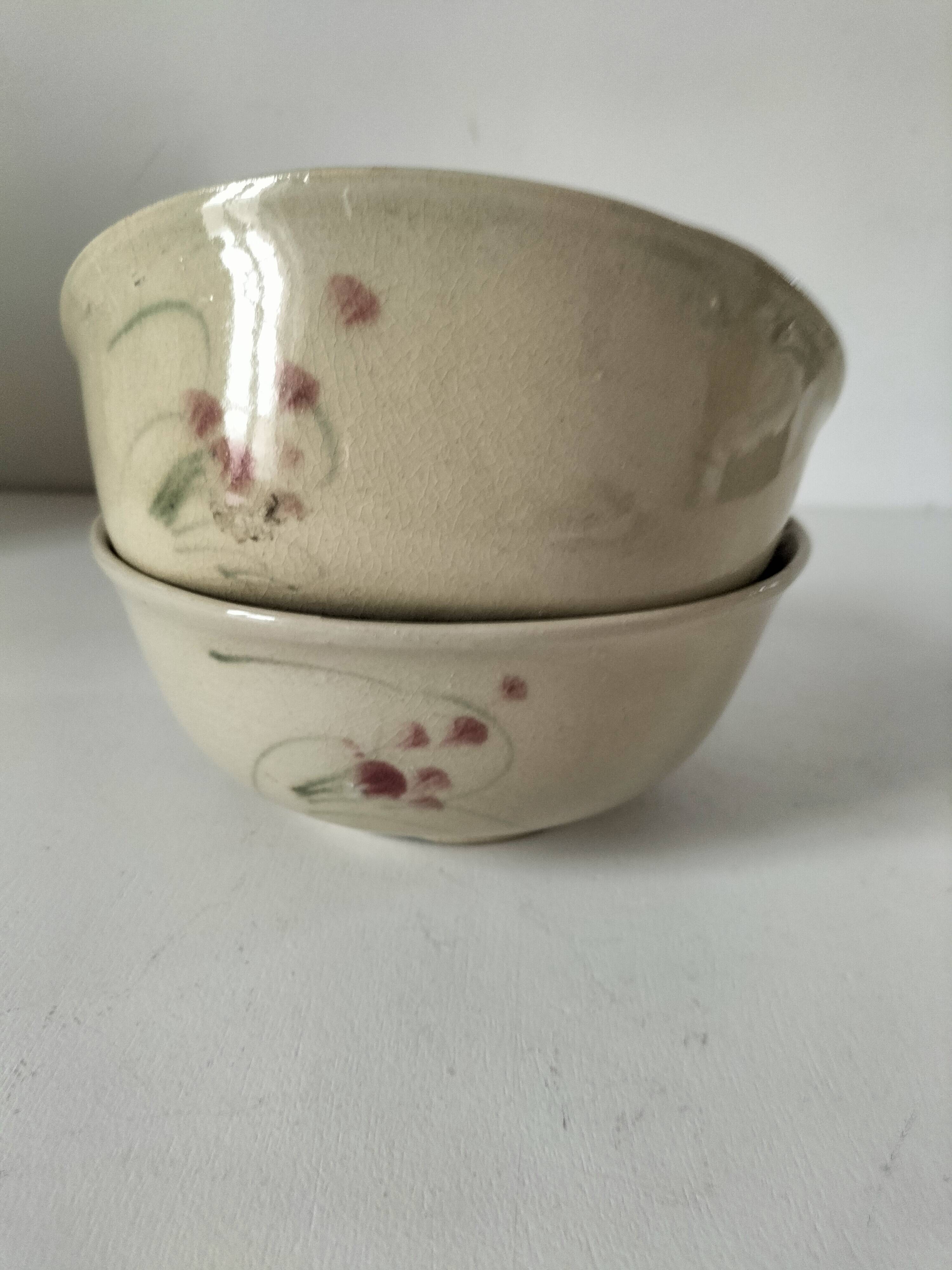 Two large vintage bowls in pastel decor on mini pedestals.