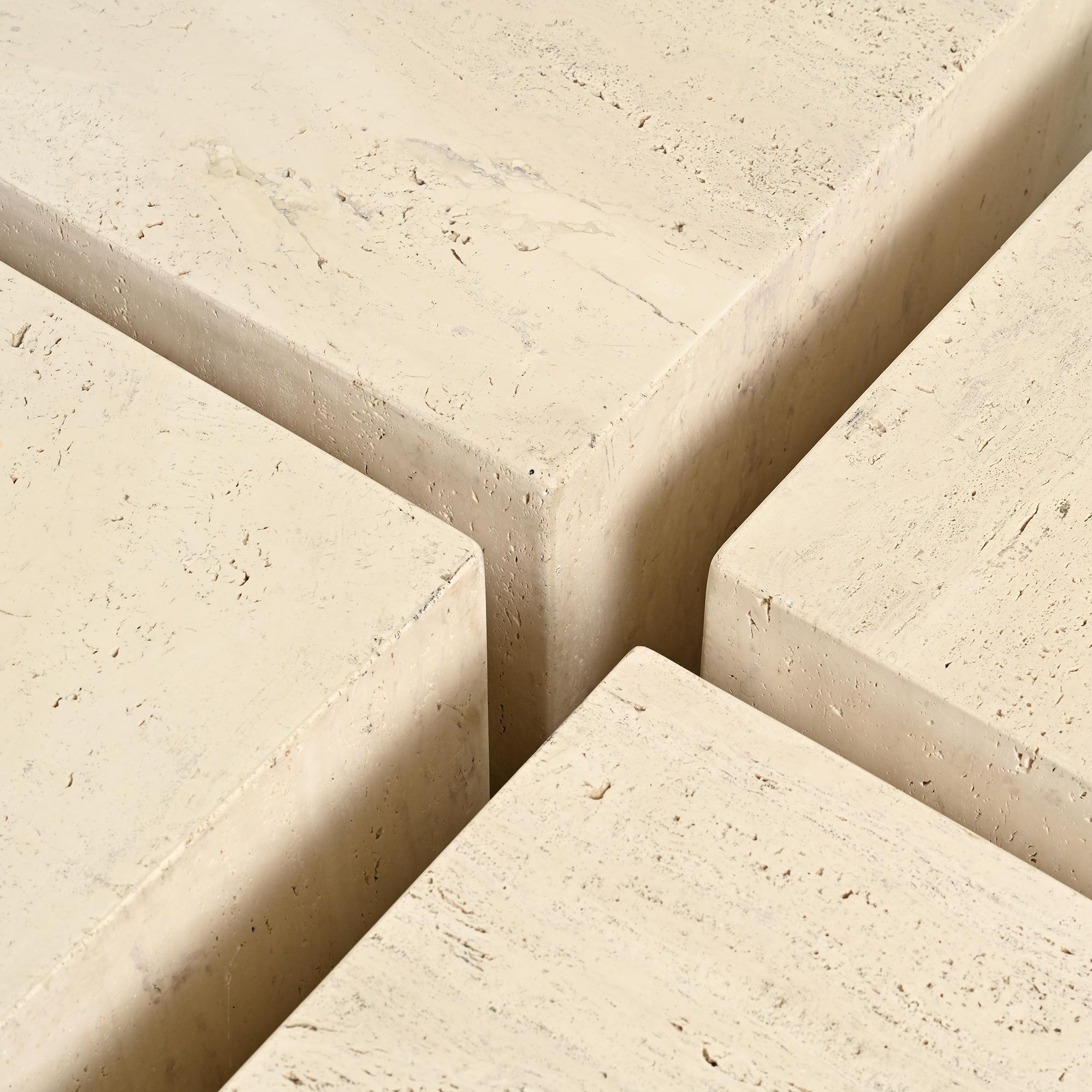 Set of four side tables in travertine, Italy, 1970s.
