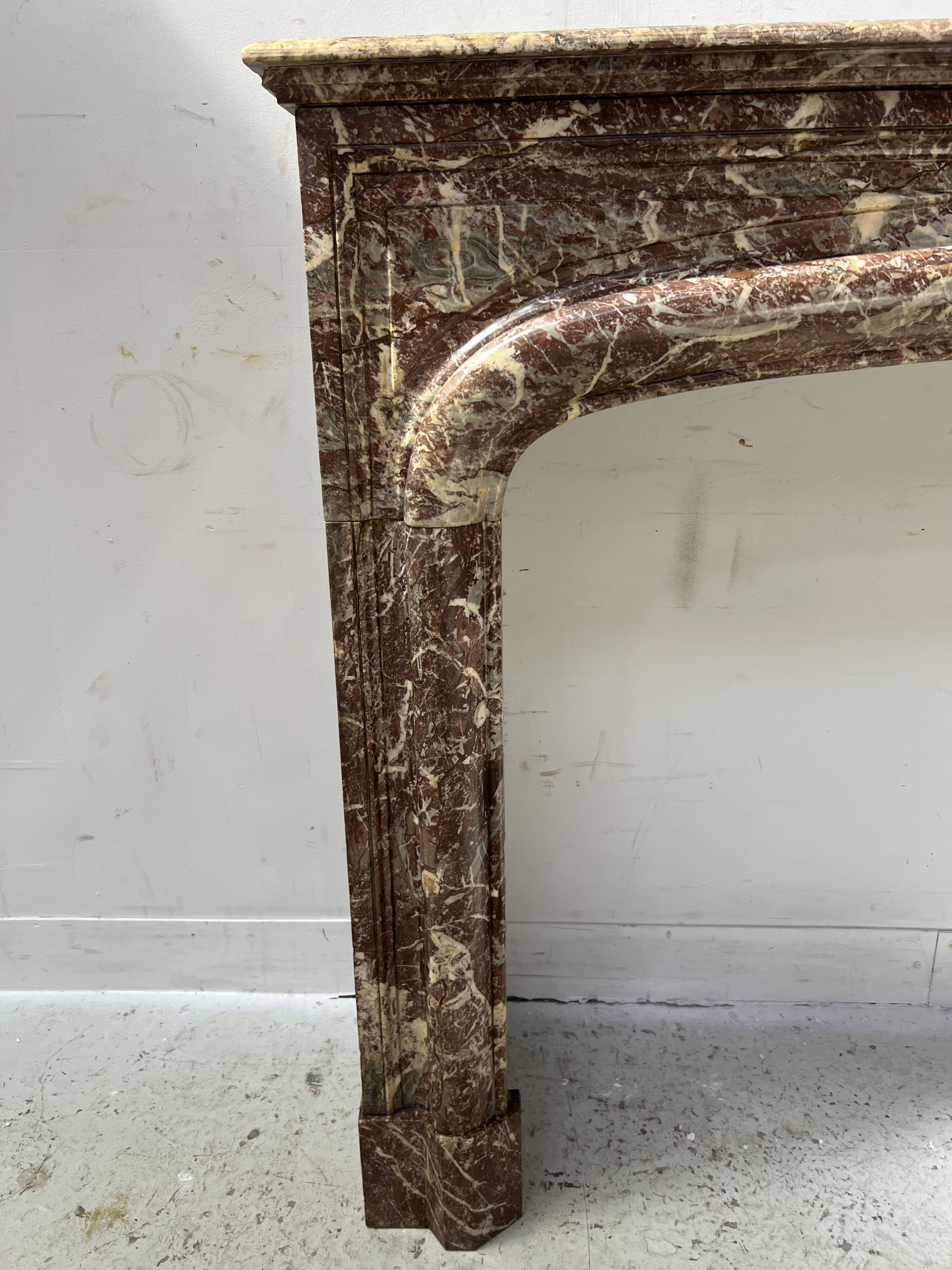 Louis XIV style fireplace in speckled red marble, 19th century.