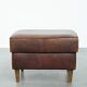 Sturdy vintage sheepskin ottoman in a beautiful large size with black piping